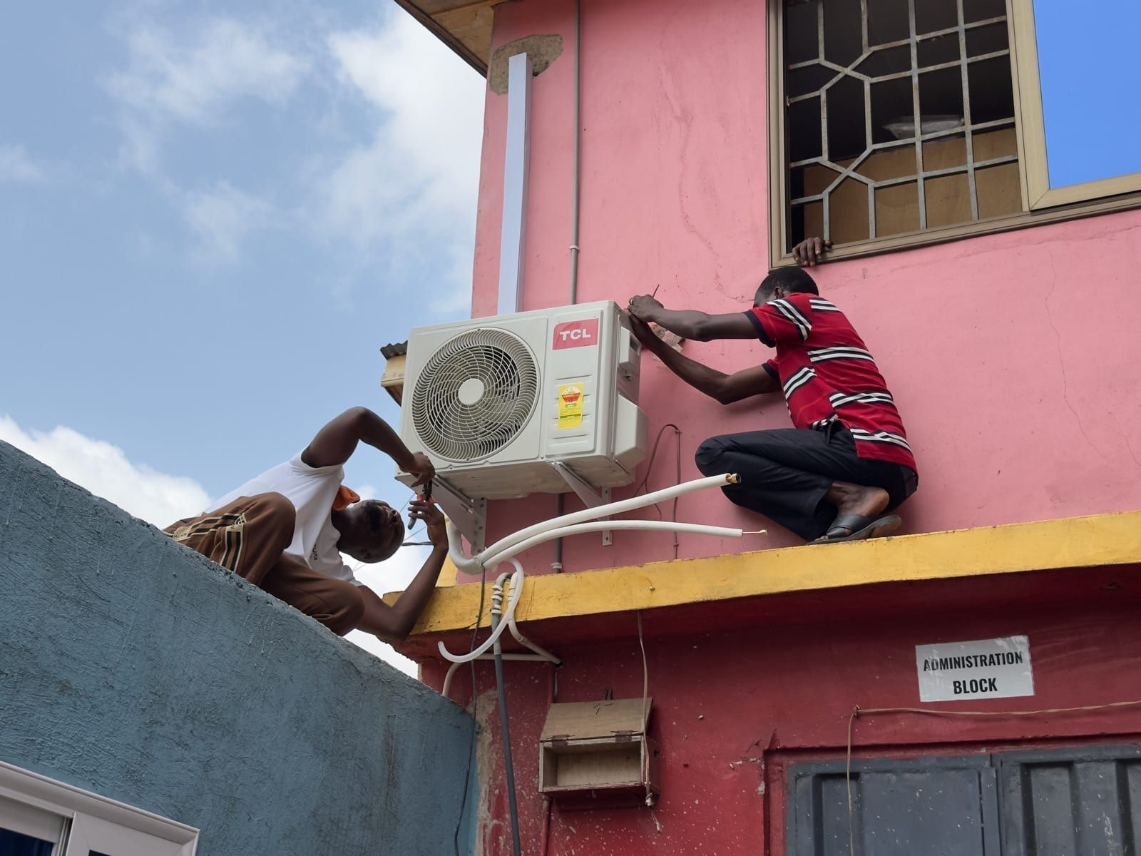 Handwerker installieren eine Klimaanlage am Admin-Block