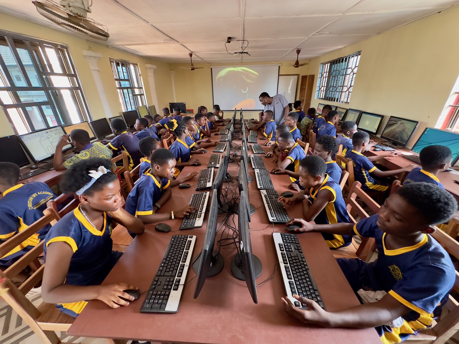 Computerraum in Kumasi mit Beamer und Schüler an über 40 PCs